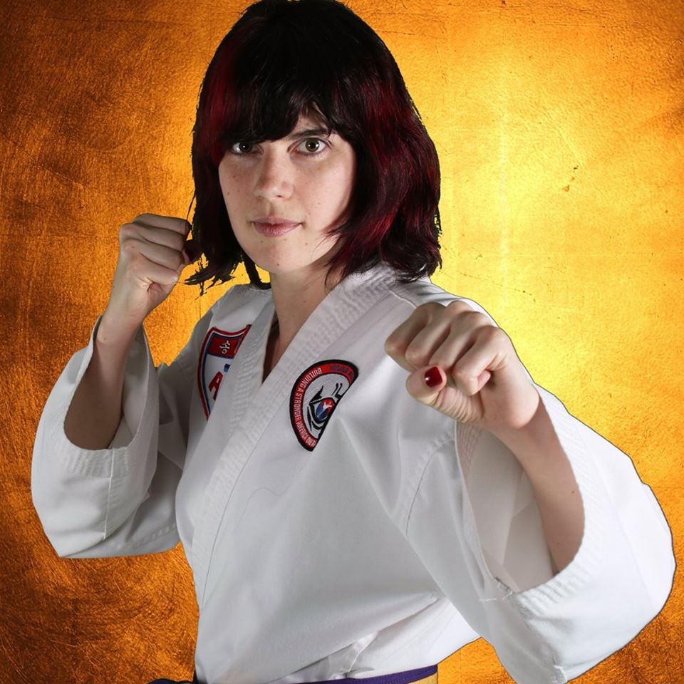 Angela in her Taekwondo uniform, fists up, ready to back up your team with immaculate paperwork.